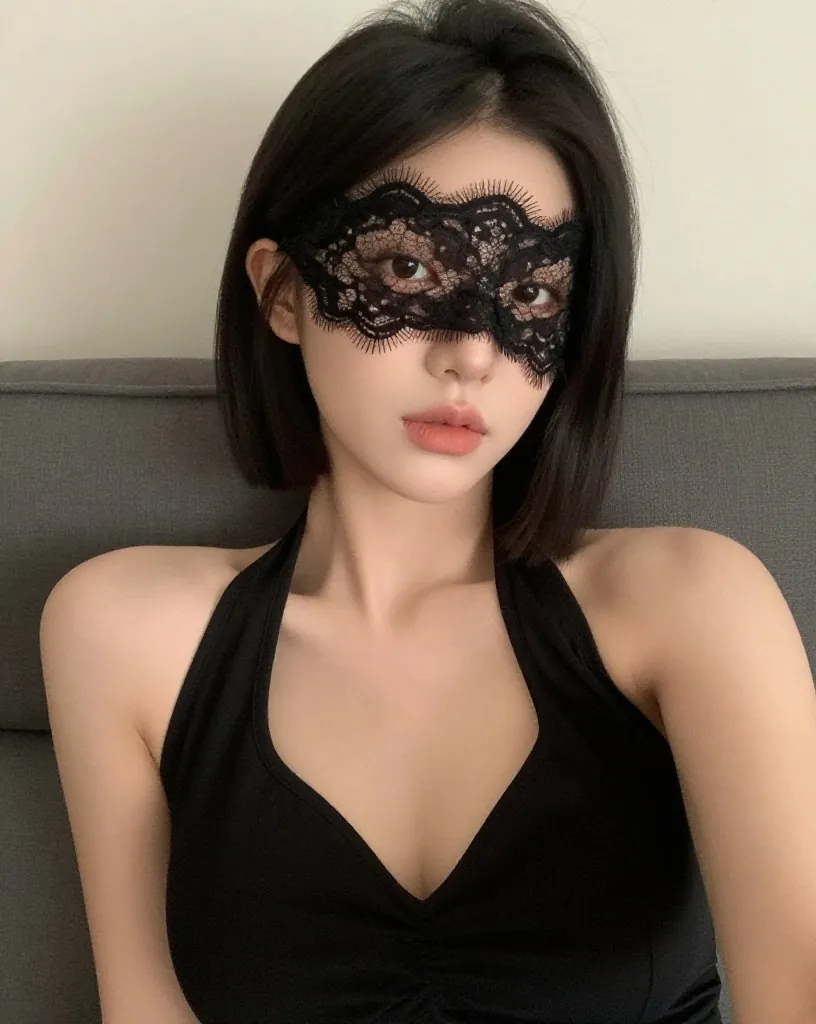 검은 홀터넥 원피스에 레이스 가면을 쓴 여성